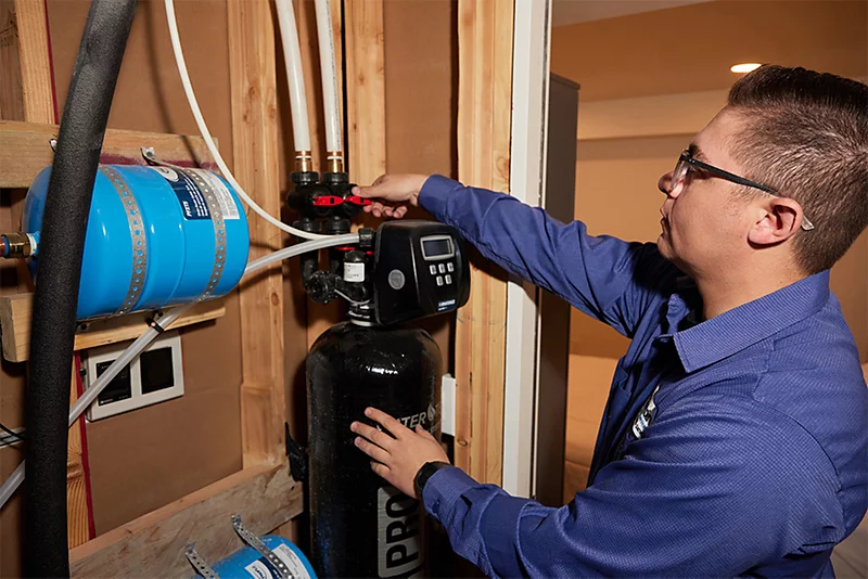 Plumbing expert in the United States installing a whole house water filter